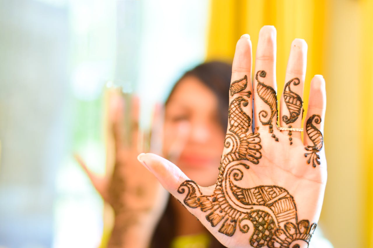 portfolio-06 Close-up of a womans hand with intricate henna design, symbolizing tradition and artistry.