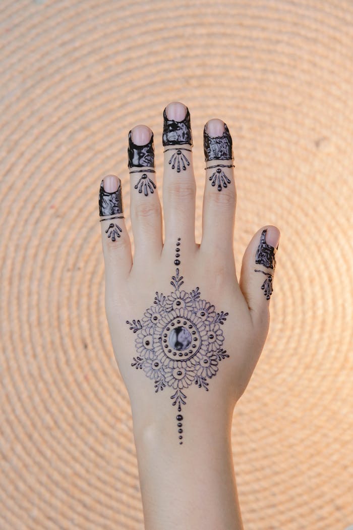 portfolio-02 Intricate henna design on a womans hand, showcasing cultural artistry indoors.