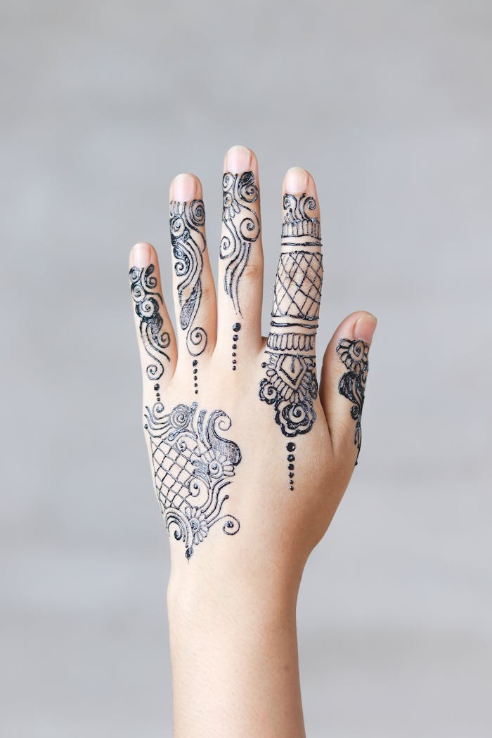 portfolio-01 Close-up of an elegant henna mehndi design on a womans hand, showcasing intricate patterns.
